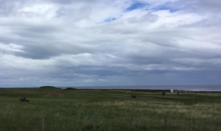 Coastal links Golf course with greenkeepers at work